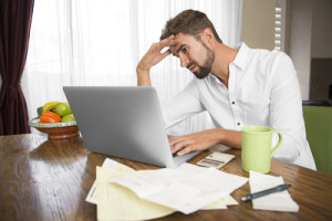 Frustrated man trying to do his taxes at home